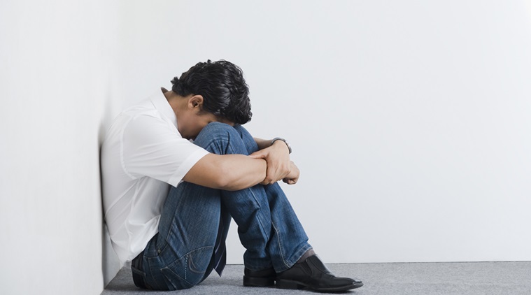 University student sitting in the corner with head down كيف تنسى شي يزعجك