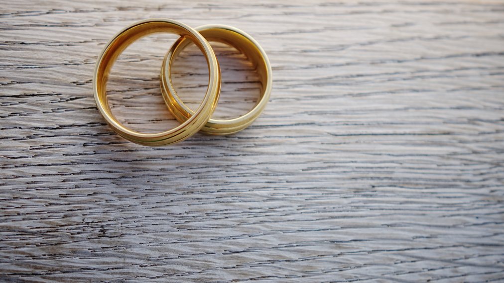 Close-Up Of Wedding Rings On Table هل تحليل الزواج يحتاج صيام